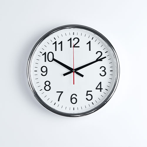 Eine runde weiße Wanduhr vor weißem Hintergrund.