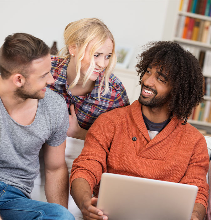 Drei Personen, die sich anlachen.